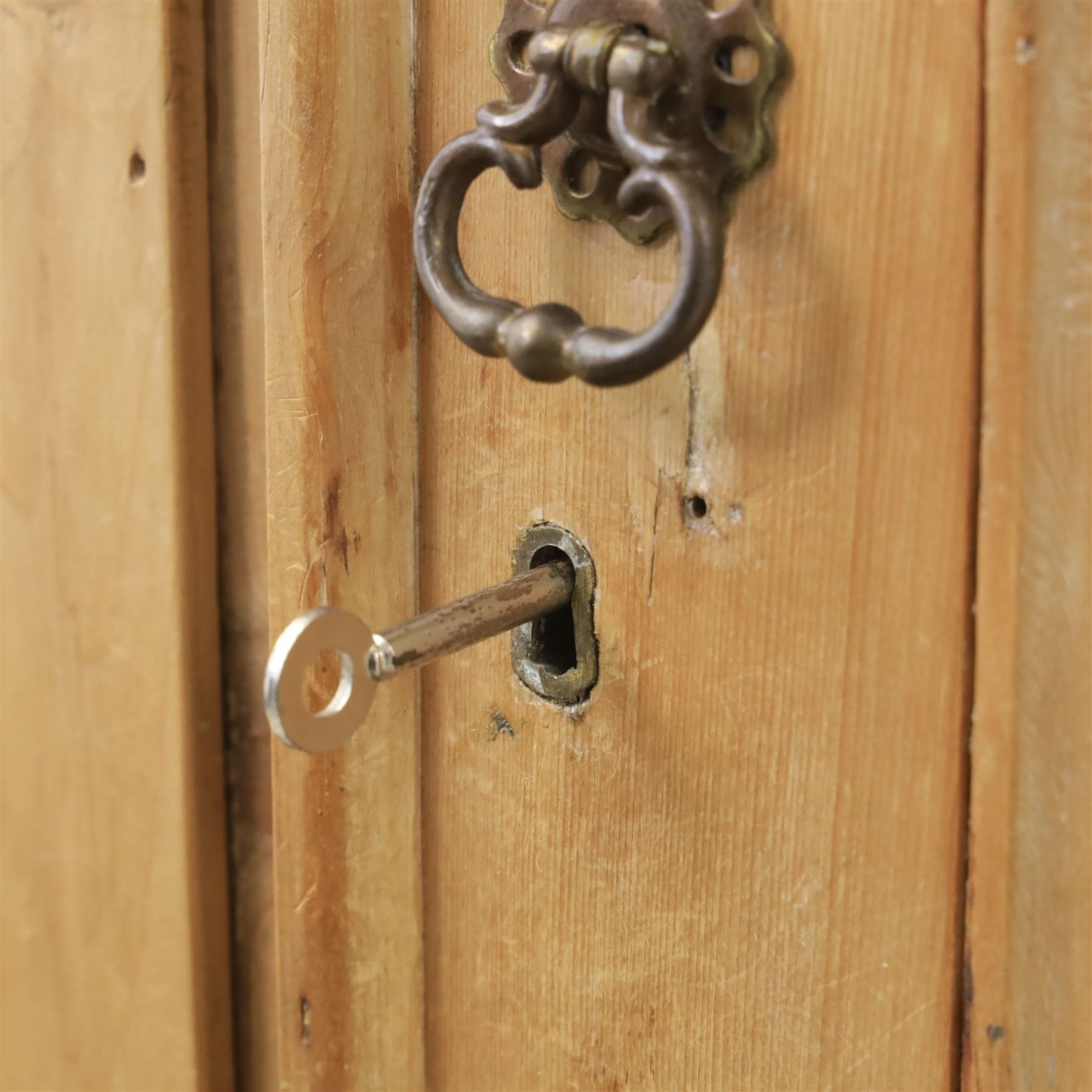 Traditional waxed pine single wardrobe, featuring single panelled door above base drawer, loop handles