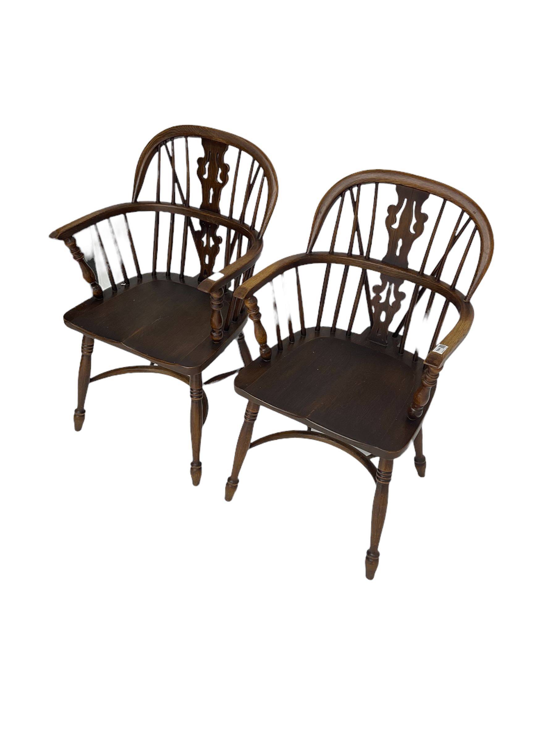 Pair late 20th century oak Windsor elbow chairs, double hoop and stick back with pierced and fretwork work splat, dished seat on turned supports joined by crinoline stretcher