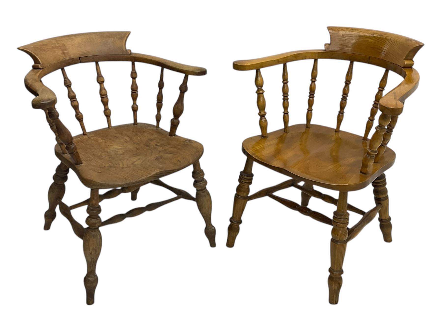 Late 19th century elm smoker’s bow armchair, curved top rails over turned spindle backs, shaped seats, raised on turned legs united by turned stretchers; together with a similar smoker’s bow armchair (2)