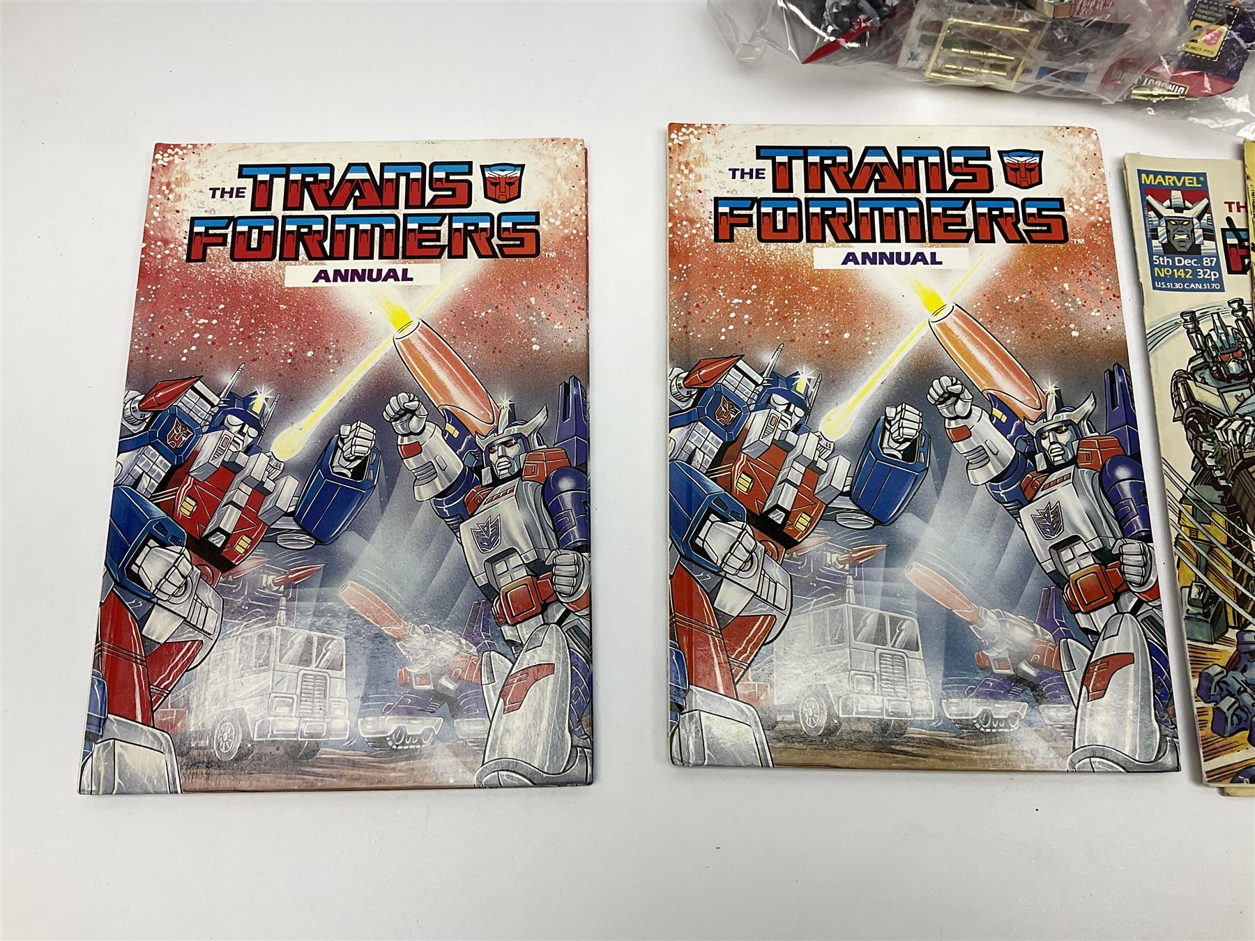 Four 1980sTransformer G1 - Optimus Prime 1984; DinoBot Sludge (Diplodocus) 1984; Cyclonus 1986; and Runamuck 1986; with paperwork; seven Bandai Robo Machines Robots/Transformers; almost fully stocked Panini Sticker album; two annuals; three comics; two posters; and Ladybird story book