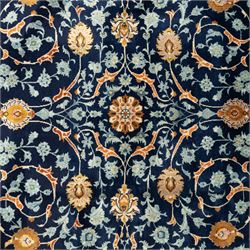 Persian Kashan carpet, navy field with an all-over design of scrolling vines, palmettes and rosettes in gold and pale blue, enclosed by multiple floral borders with stylised palmette motifs, originating from Central Iran