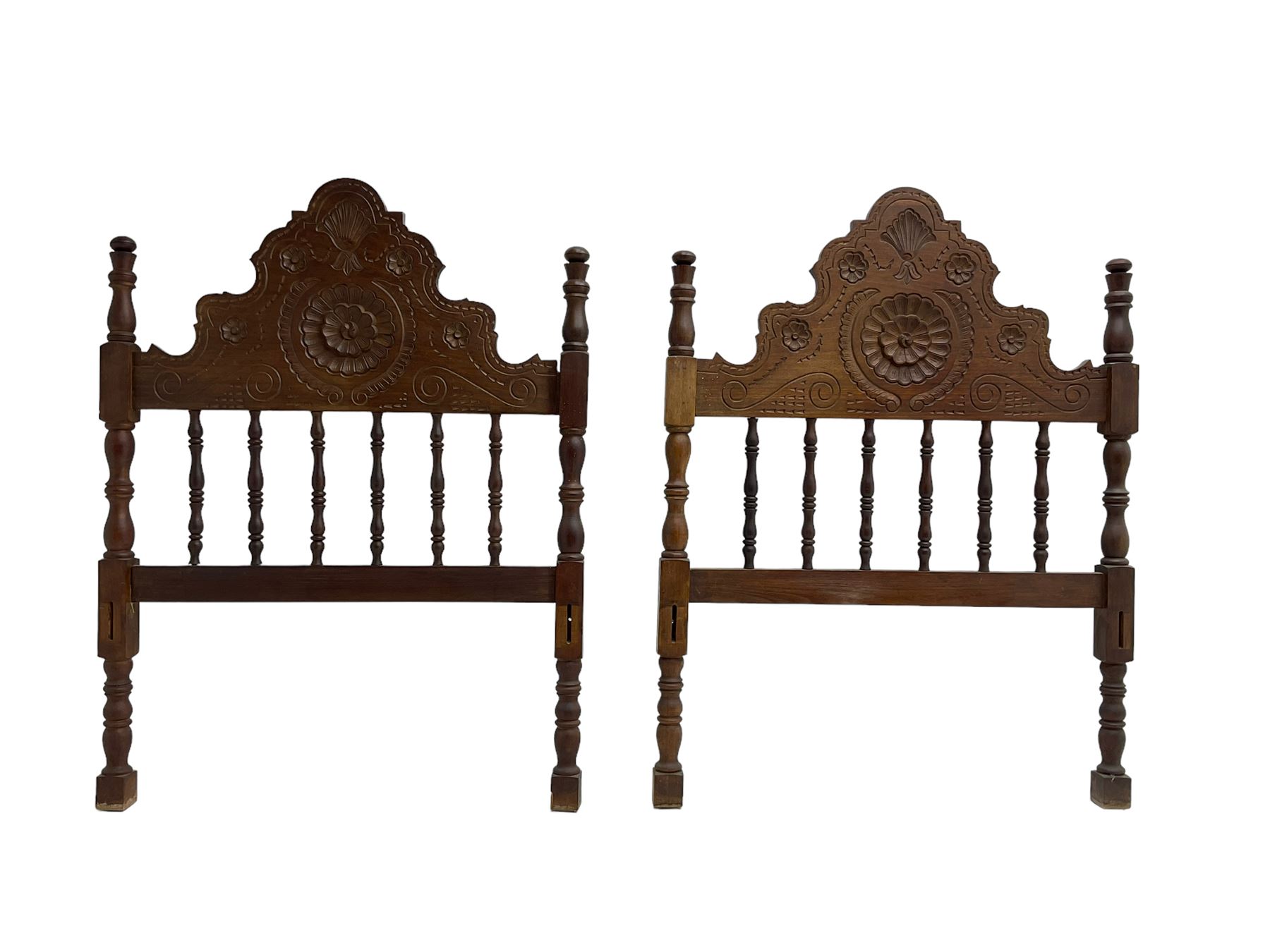 Pair Spanish stained beech single 3' bedsteads, spindle turned backs and carved with scrolling floral decoration 
