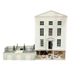 Honeychurch kit-built large wooden dolls house as a 19th century style double fronted four storey town house; with stucco finish under a pitched roof with Palladian style pediment and simulated tiles; protruding front courtyard with railings, street light and steps giving access to two fully furnished basement rooms; central door with Ionic columns and entablature; double hinged front facade opening to reveal a fully furnished interior with hall, stairs and landings and two rooms on each floor; wired for electric wiring W67cm H102cm D58cm