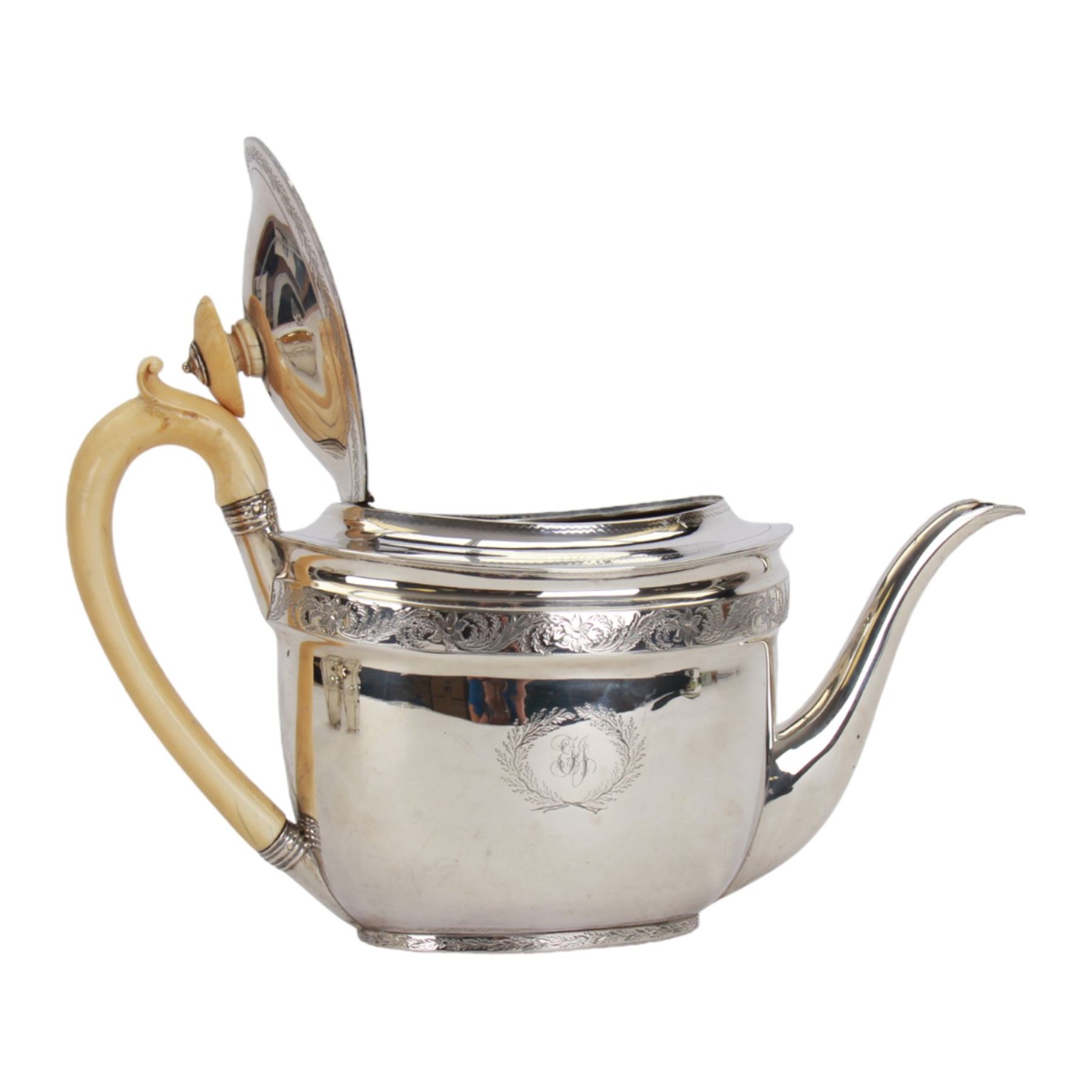George III silver three piece tea service, comprising teapot with ivory scroll capped curved handle and ivory finial to the hinged cover, twin handled open sucrier with gilt interior, and cream jug with gilt interior, each of oval form with rounded sides, the bodies engraved with central monogram within a seaweed wreath, between engraved foliate bands, hallmarked John Emes, London 1801, teapot including handle H17cm

This item has been registered for sale under Section 10 of the APHA Ivory Act