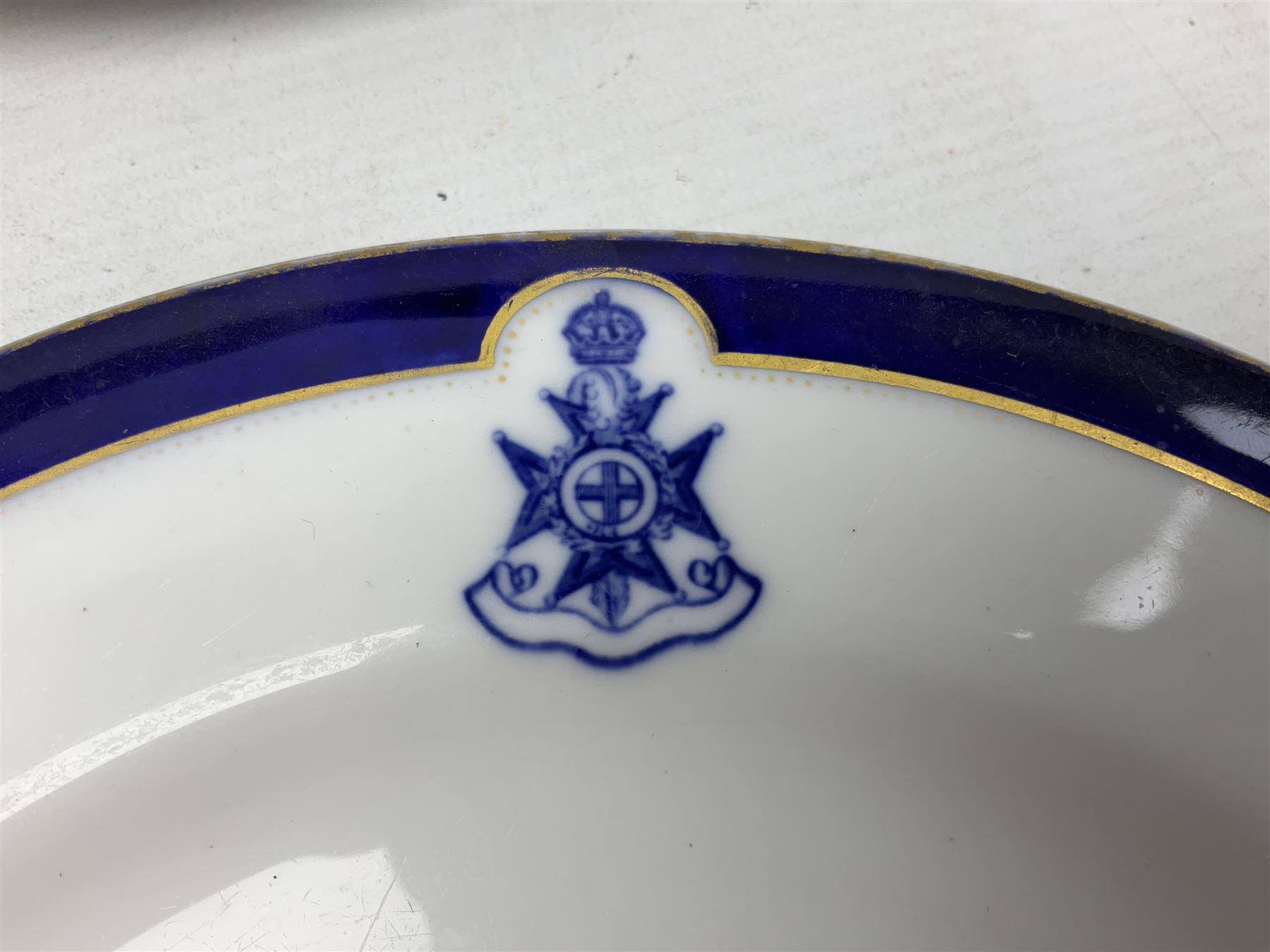 Collection of Regimental dinner wares, Comprising Royal Sussex; two dinner plates, two side plates and a soup bowl, Royal Leicestershire; two dinner plates, East Yorkshire Regiment side plate and Gordon Highlanders side plate, all decorated with the regiment's crests and blue and gilt boarders (9)