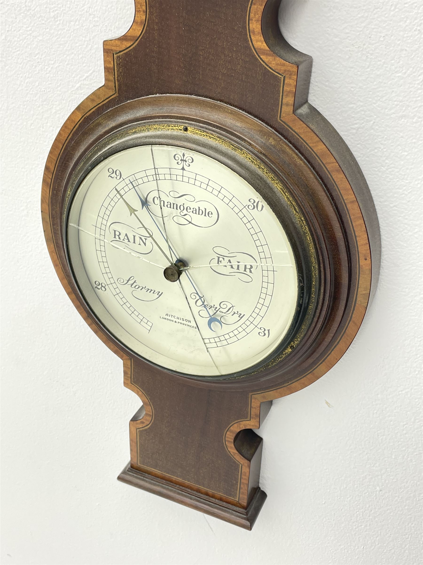 Early 19th century mahogany banjo barometer, scroll pediment over dry/damp and thermometer dials with brass registers, by ‘Crowden & Garrod, London’ (H107cm), and an early 20th century walnut and satinwood banded barometer by ‘Aitchison, London’ (H96cm)