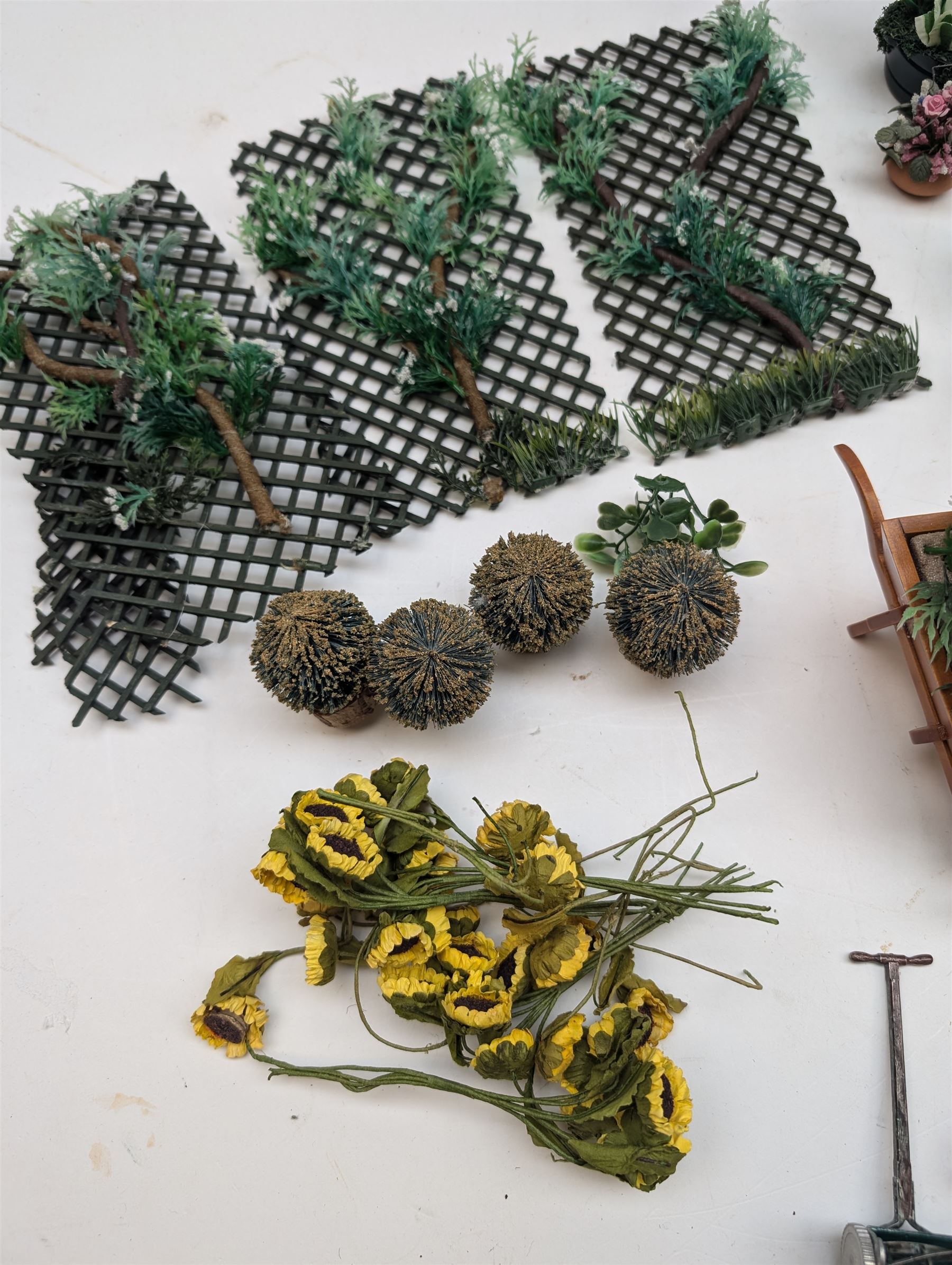 1:12 scale dolls house allotment and garden accessories, including wooden shed on a stone effect base, two vegetable patches, terracotta plant pots with flowers and foliage, stone effect plant pots, other planters, loose sunflowers, scarecrow, rabbit hutch, garden tools, fencing panels, etc 