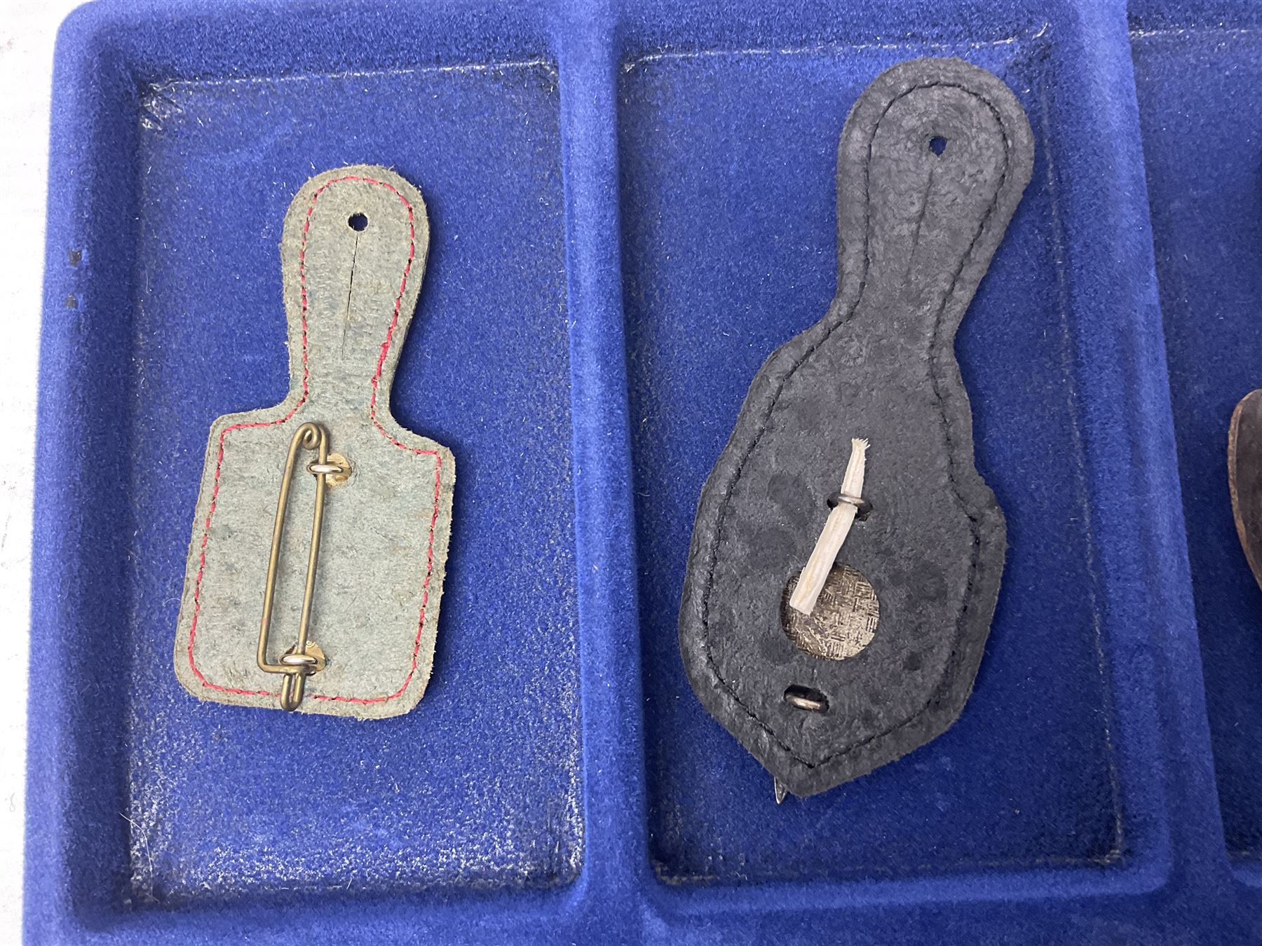 Twelve French military metal badges mounted on leather fobs including Legion, Artillery, Parachutist, Air Force, Infantry etc