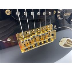 Copy of a Fender Stratocaster electric guitar in black with Wilkinson bridge, lock-in tuners, synchronised tremolo and various patent numbers; L99cm; in hard carrying case with strap and digital tuner