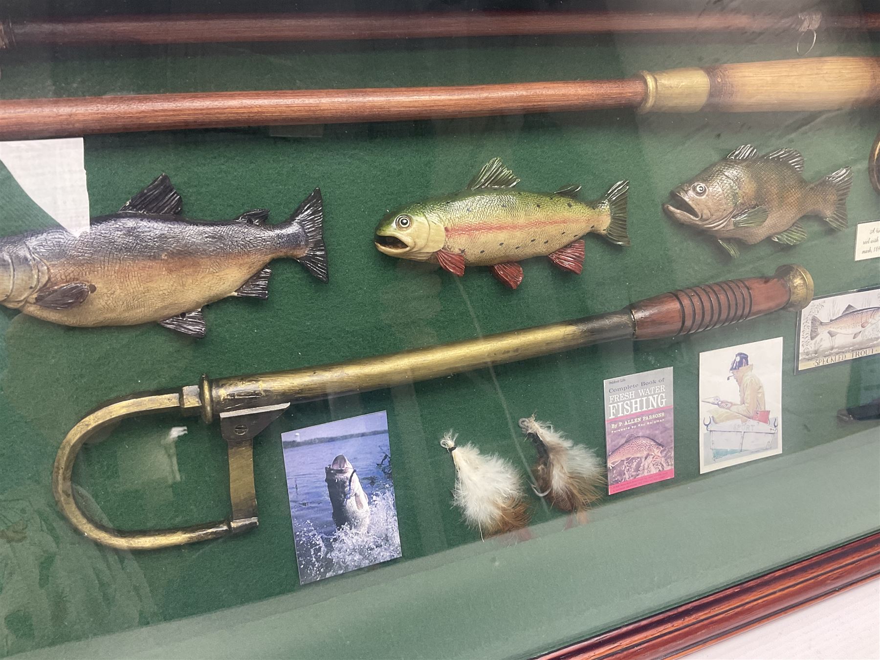 Four framed sporting memorabilia displays, the largest example containing 1930s cricket memorabilia, together with two fishing displays and a football display, each within wooden glazed frames, largest H105cm