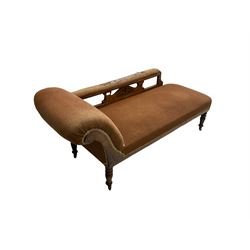 Late 19th century walnut framed chaise longue, scrolled back with pierced and carved arm rail, sprung seat upholstered in dark coral fabric, raised on turned supports with castors
