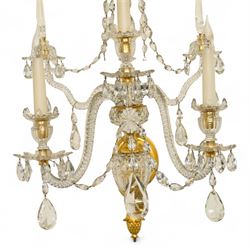 Pair of George III ormolu and cut-glass wall-lights, each with a tall central urn-shaped finial above a series of faceted glass spires and scrolled branches, the ormolu-mounted nozzles and drip pans hung with festoons of cut-glass drops and pear-shaped pendants, the lower section centred by a pineapple finial, wired for electricity