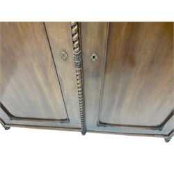 Early 20th century Italian walnut armoire wardrobe, the pierced and scrolling pediment carved with acanthus leaf detail, flanked by two scrolling cartouche with matching corbels below, the two panelled doors with applied carved rinceaux slips, with a central spiral turned upright, enclosing single shelf and hanging rail, raised on scroll feet