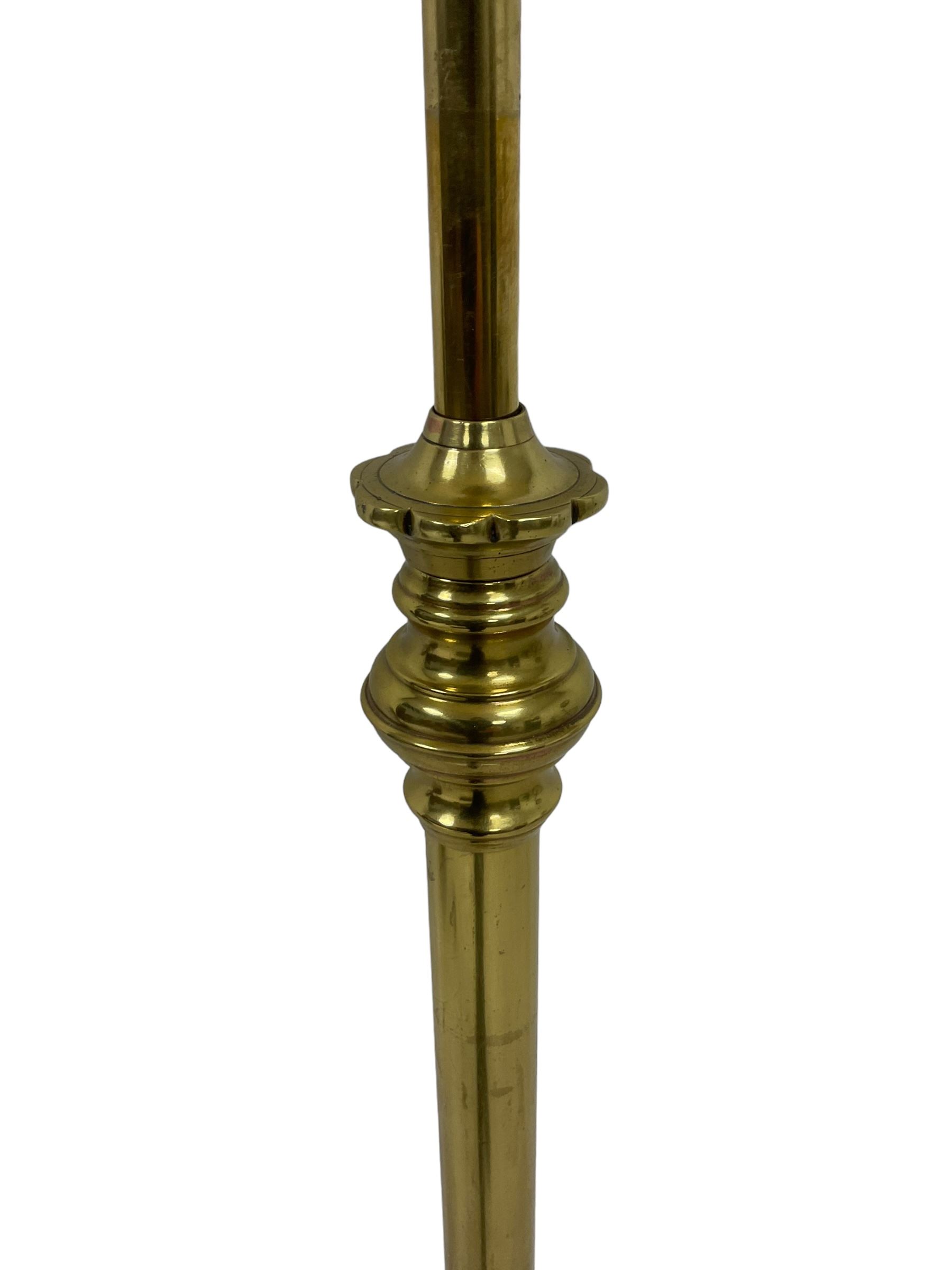 Edwardian brass plated copper standard lamp, telescopic stem on lobe moulded circular base with three projecting paw feet, with cream shade