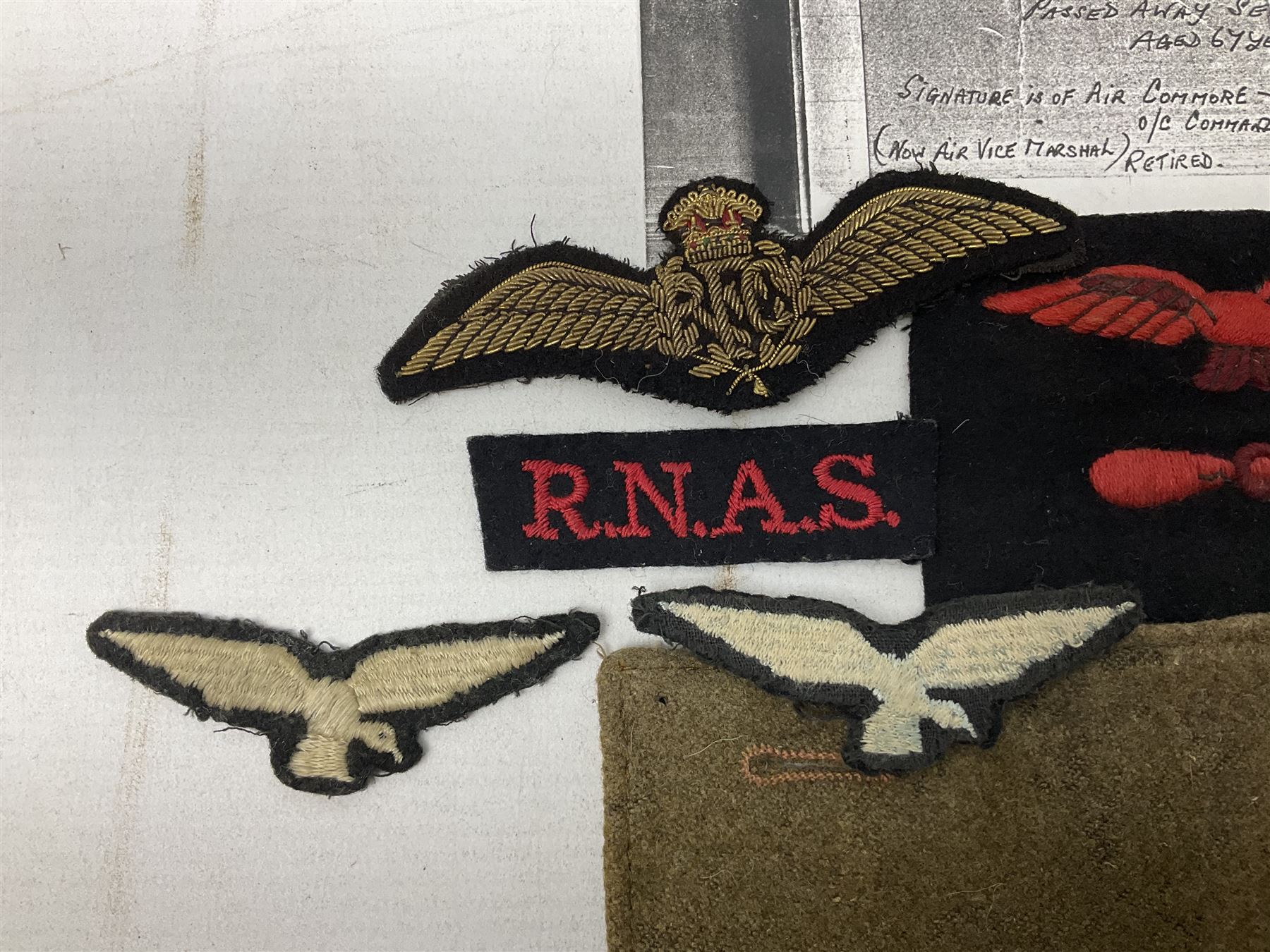 WW1 British Army Derby Scheme 1915 Attested armband; beret with East Yorkshire cap badge; pair of fur lined leather flying/motorcycle goggles; HMS Pembroke cap band; and small quantity of RNAS cloth and metal badges etc