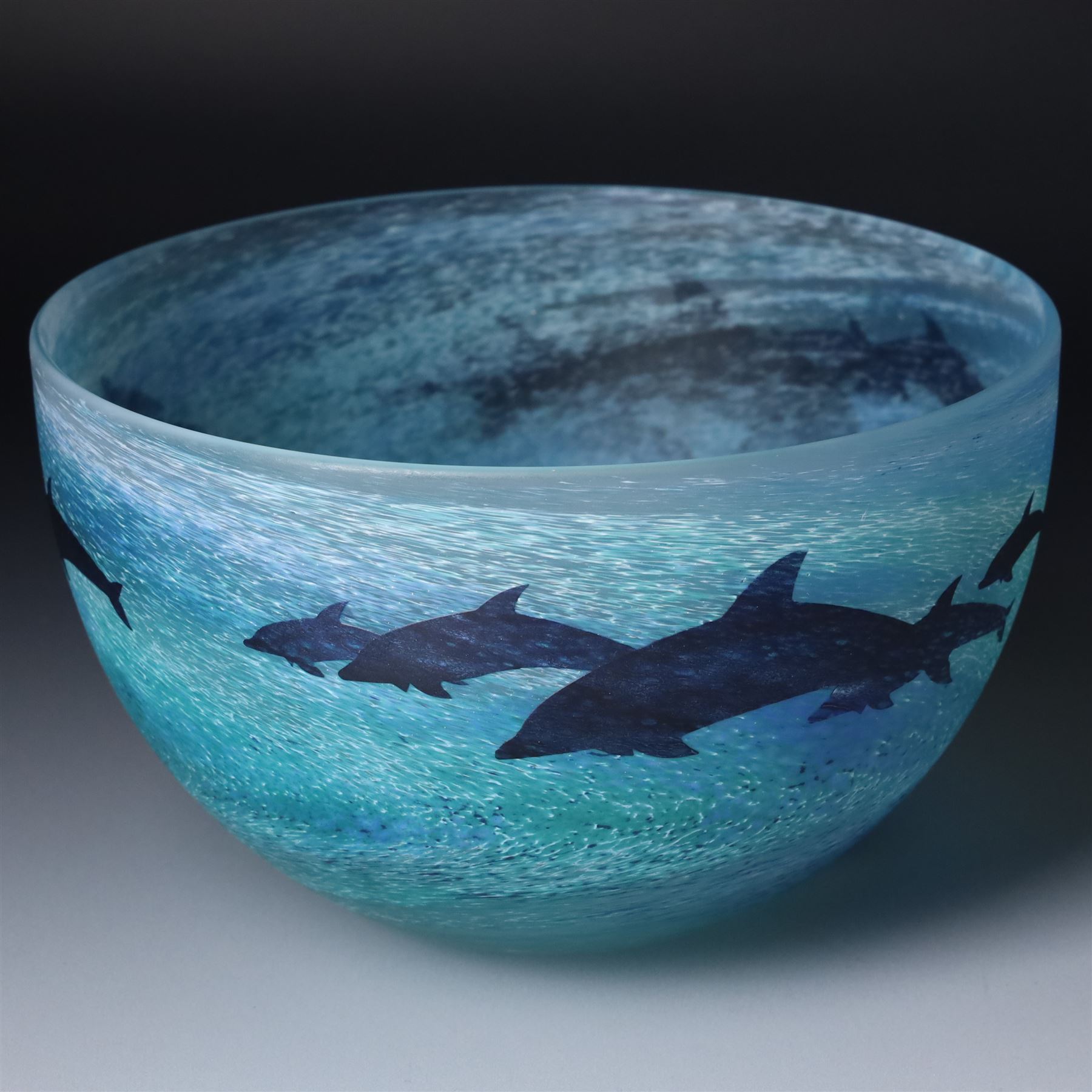Malcolm Sutcliffe (British 1954-): Studio glass cameo bowl, the body mottled and speckled with shades of blue decorated with dolphins, etched signature, D18cm and matching paperweight (2)