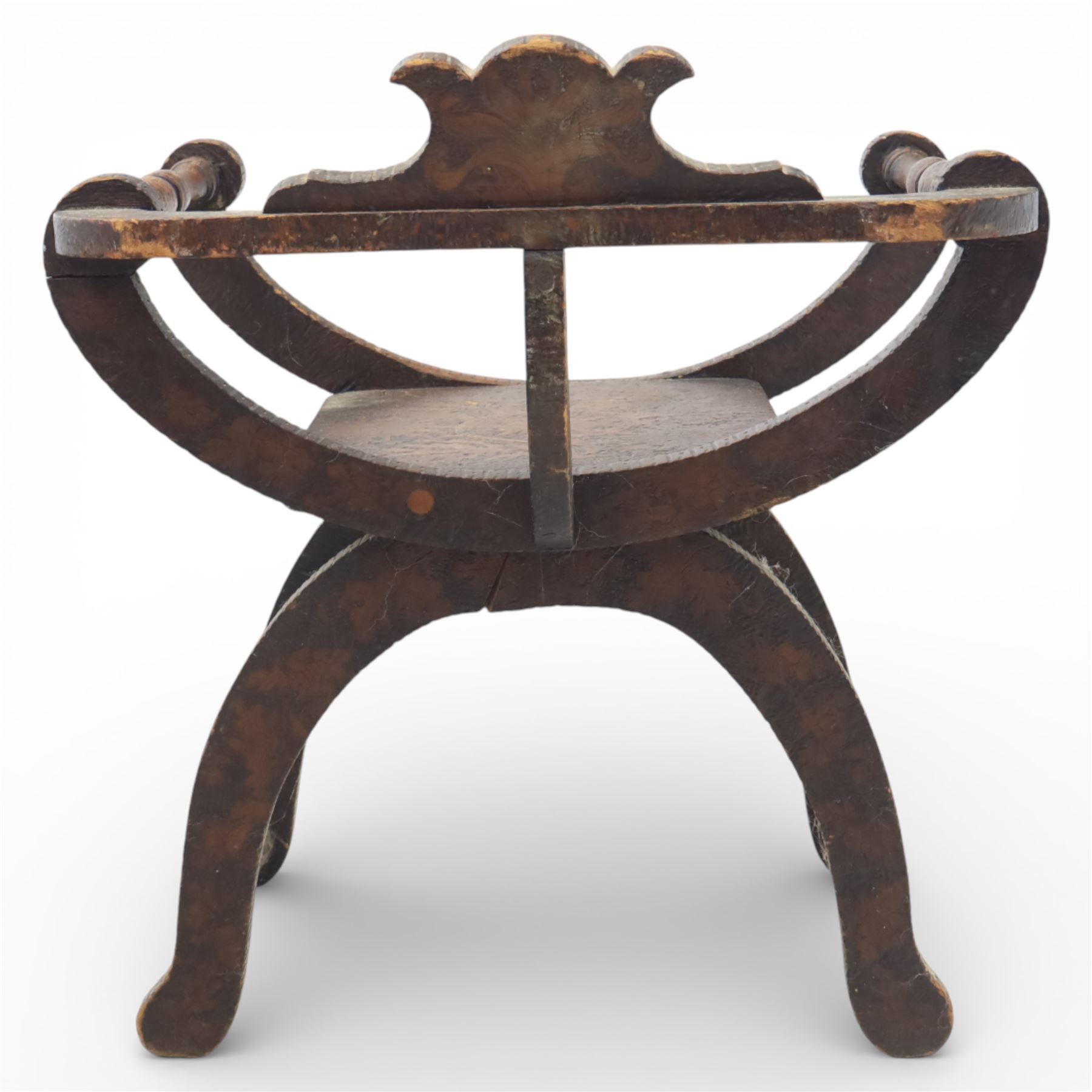 Late 19th century Savonarola style oak chair, X-frame construction with carved and shaped cresting rail, the curved arms with chip carved decoration, turned horizontal supports, solid dished seat with adzed surface, raised on shaped splayed feet