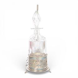 Late 19th century silver plated Silber & Fleming triple decanter stand, the three cut glass decanters with spire stoppers housed within foliate and scroll pierced bottle sleeves, upon a tripart base with six scroll feet, the base mounted with articulated x-frame curved handle, including handle when positioned upright H35.5cm, W34cm