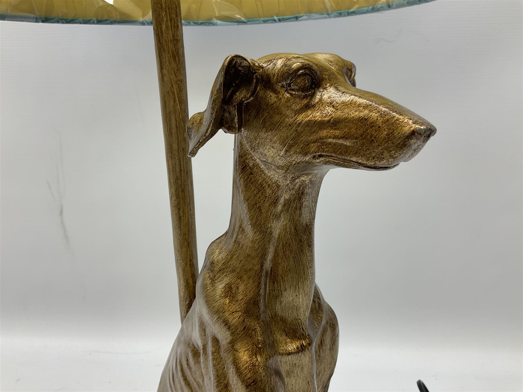 Composite table lamp, modelled as a gilt seated whippet, with teal velvet shade, H71cm

