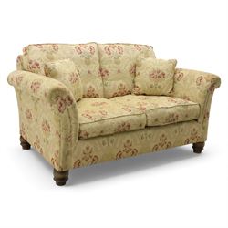 Late 20th century two seat sofa upholstered in f,oral beige and red fabric, turned supports 