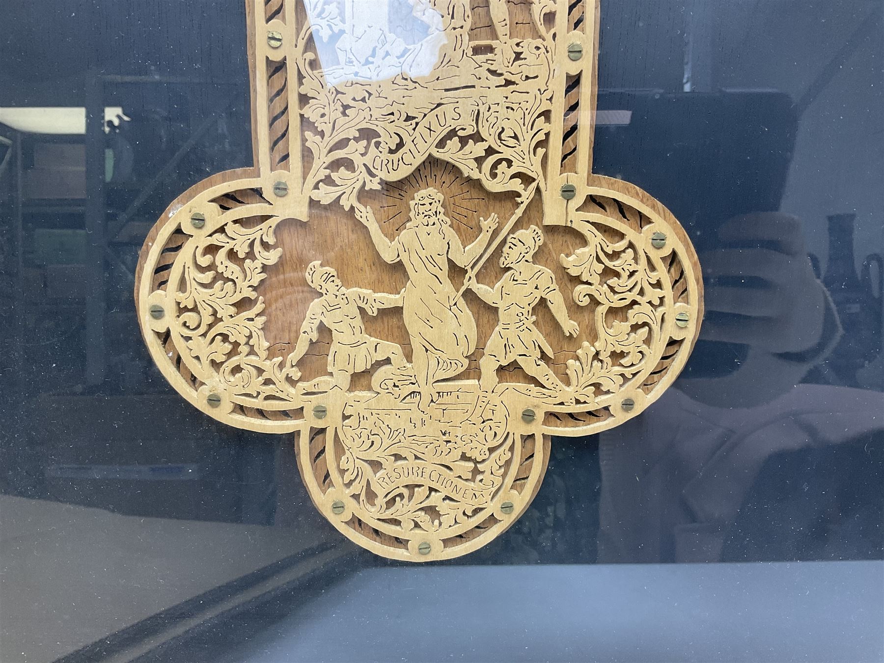 Cork carving of a religious cross depicting intricate scenes of various religious figures and motifs amongst trees and foliage, with central circular panel of Jesus Christ, in glazed frame, H95cm