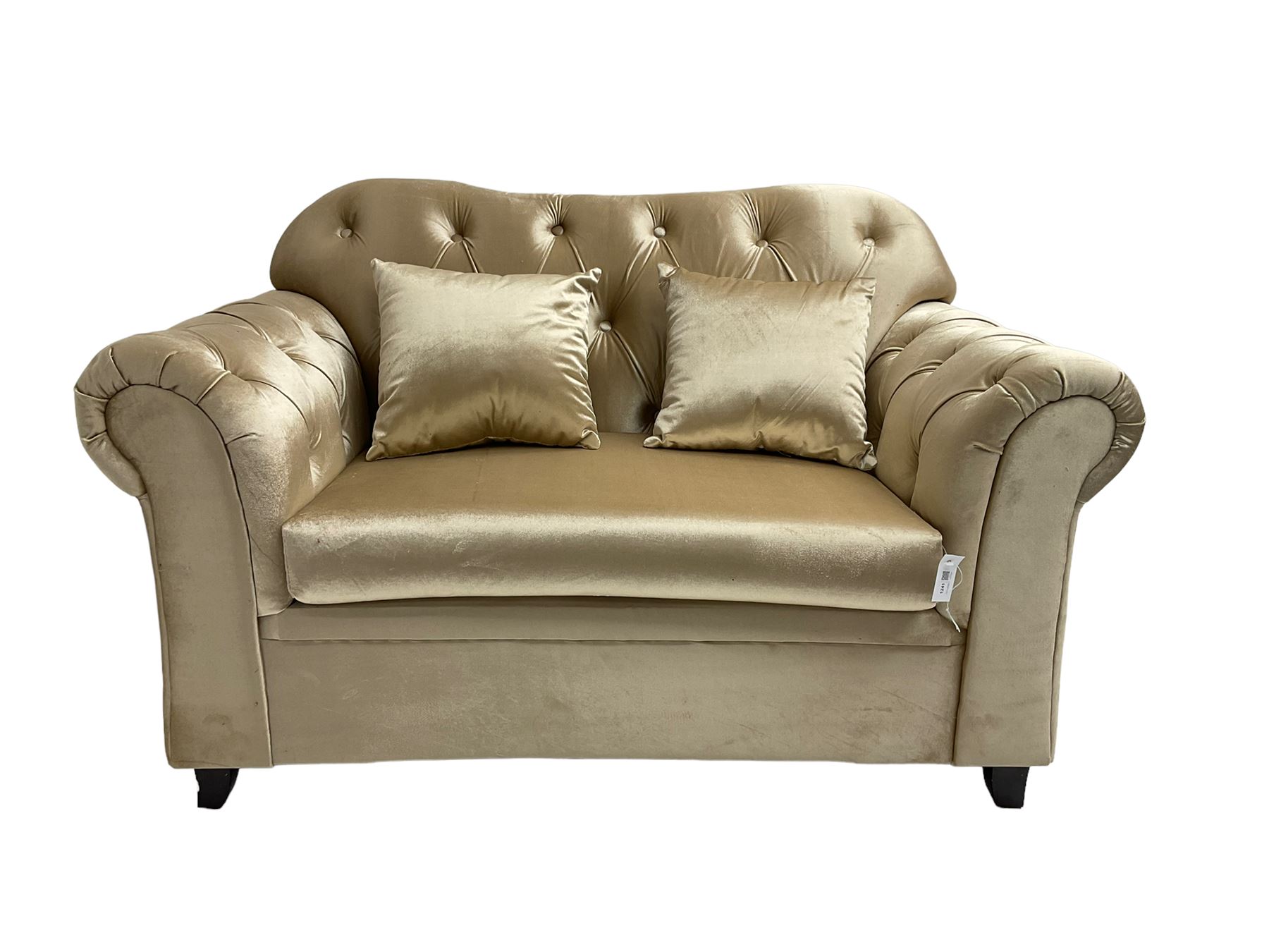 Chesterfield shaped snuggler sofa, upholstered in buttoned champagne fabric, with scatter