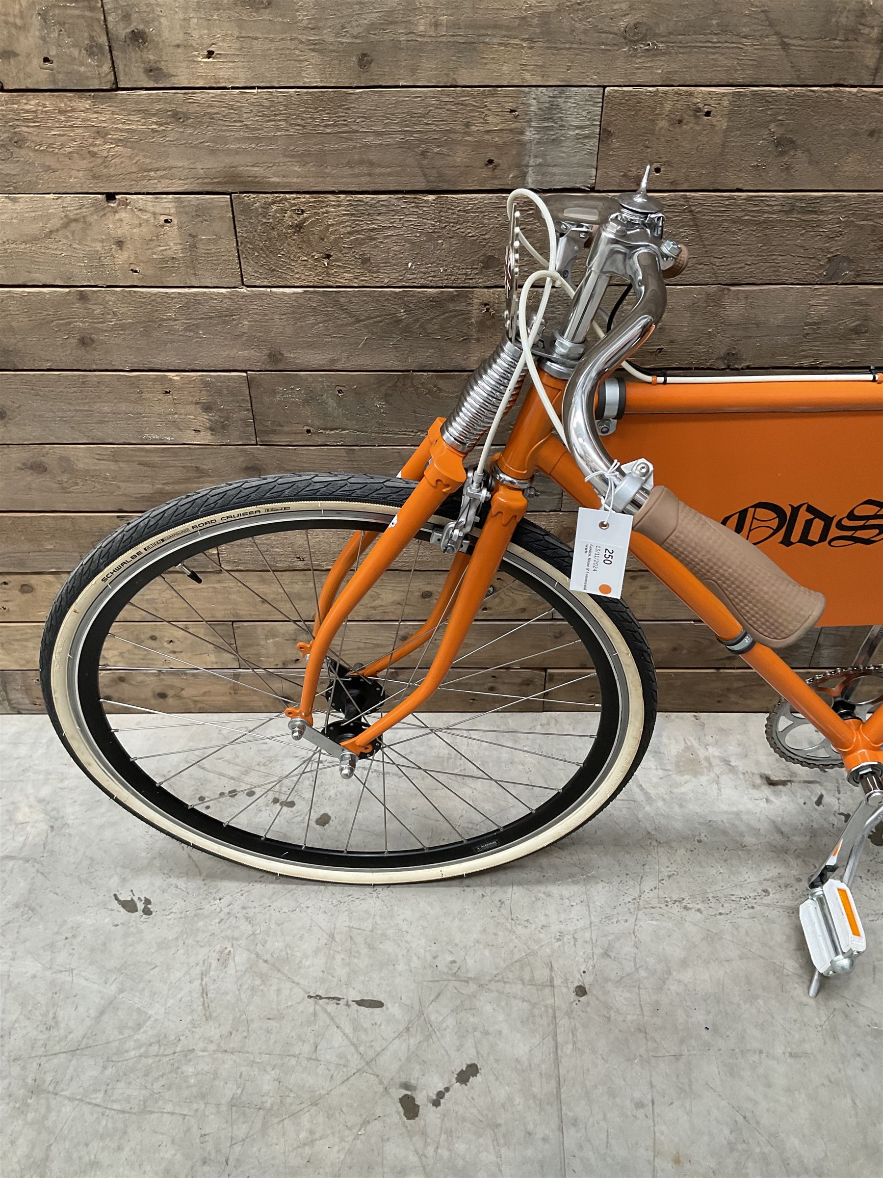 Fully restored vintage advertising bicycle with 2 stroke petrol engine, orange frame, tan leather seat