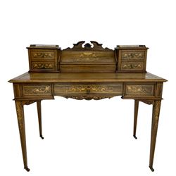 Edwardian Sheraton revival rosewood writing desk, the raised back with brass gallery fitted with central hinged compartment and four small drawers, the interior with letter divisions and pen holder, inlaid with floral garlands and boxwood stringing, rectangular moulded top inset with tooled leather writing surface over central frieze drawer with foliate scroll carved brackets, the drawer front inlaid with scrolls, urn and mythical beasts, square tapering supports inlaid with interlaced ribbon and trailing foliage, on brass castors 