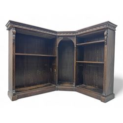 Victorian carved oak corner bookcase, L-shaped form, moulded top over lunette carved frieze, decorated with S-scroll and mask carved corbels with trailing acanthus leaves, fitted with adjustable shelves, on moulded plinth base 