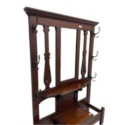Late 19th century walnut hallstand, raised central bevelled mirror over shelf and hinged compartment, fitted with umbrella and stick stands with metal drip trays, upright pierced silhouette type supports