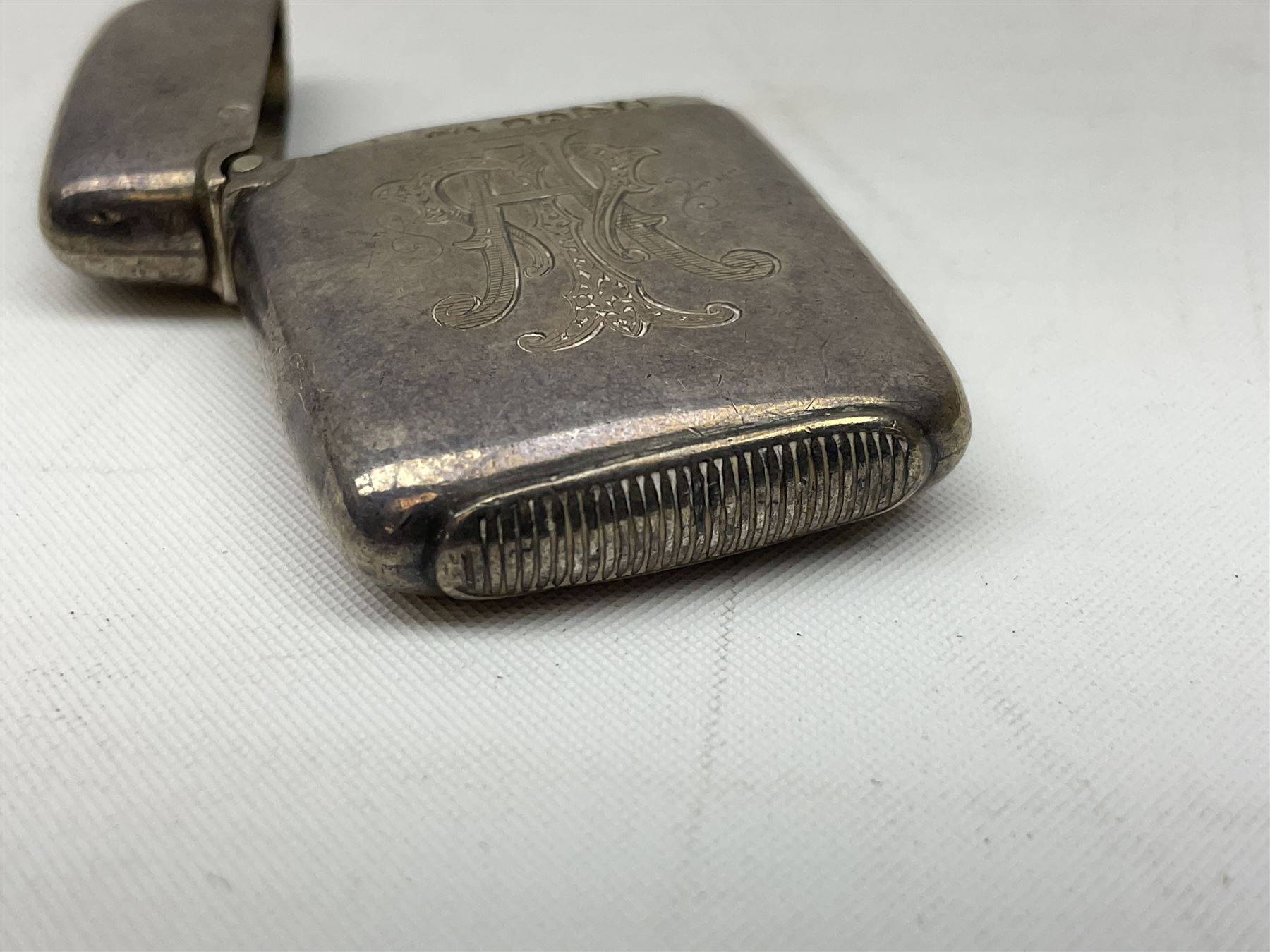 Victorian novelty brass vesta case modelled in the form of a pig holding a money bag, together with a silver vesta, hallmarked 