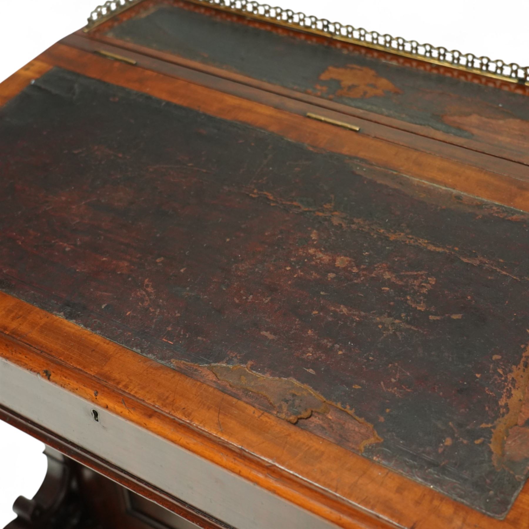 Large Victorian mahogany Davenport, the sloped leather inset writing surface opening to reveal fitted interior, with four drawers to one side and opposing dummy front cupboard door, carved scrolled supports and panelled back, raised on turned feet with brass castors 