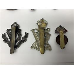 Fourteen cap badges of Irish interest including Royal Dublin Fusiliers inscribed to the slider 'From A. O'Connor 2nd Batt. Dec.2nd 1915', Connaught Rangers, South irish Horse Yeomanry, Inniskilling Fusiliers, Royal Irish Regiment etc; and seven Welsh badges including South Wales Borderers, Welsh Guards, 3rd Bn. Monmouthshire Regt. etc (21)