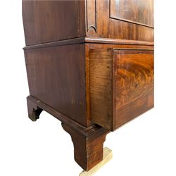 George III mahogany double wardrobe, the projecting cornice with dentil moulding over two panelled doors with mirror-lined interiors, enclosing hanging rails and brass hooks, the base fitted with two drawers, raised on bracket feet
