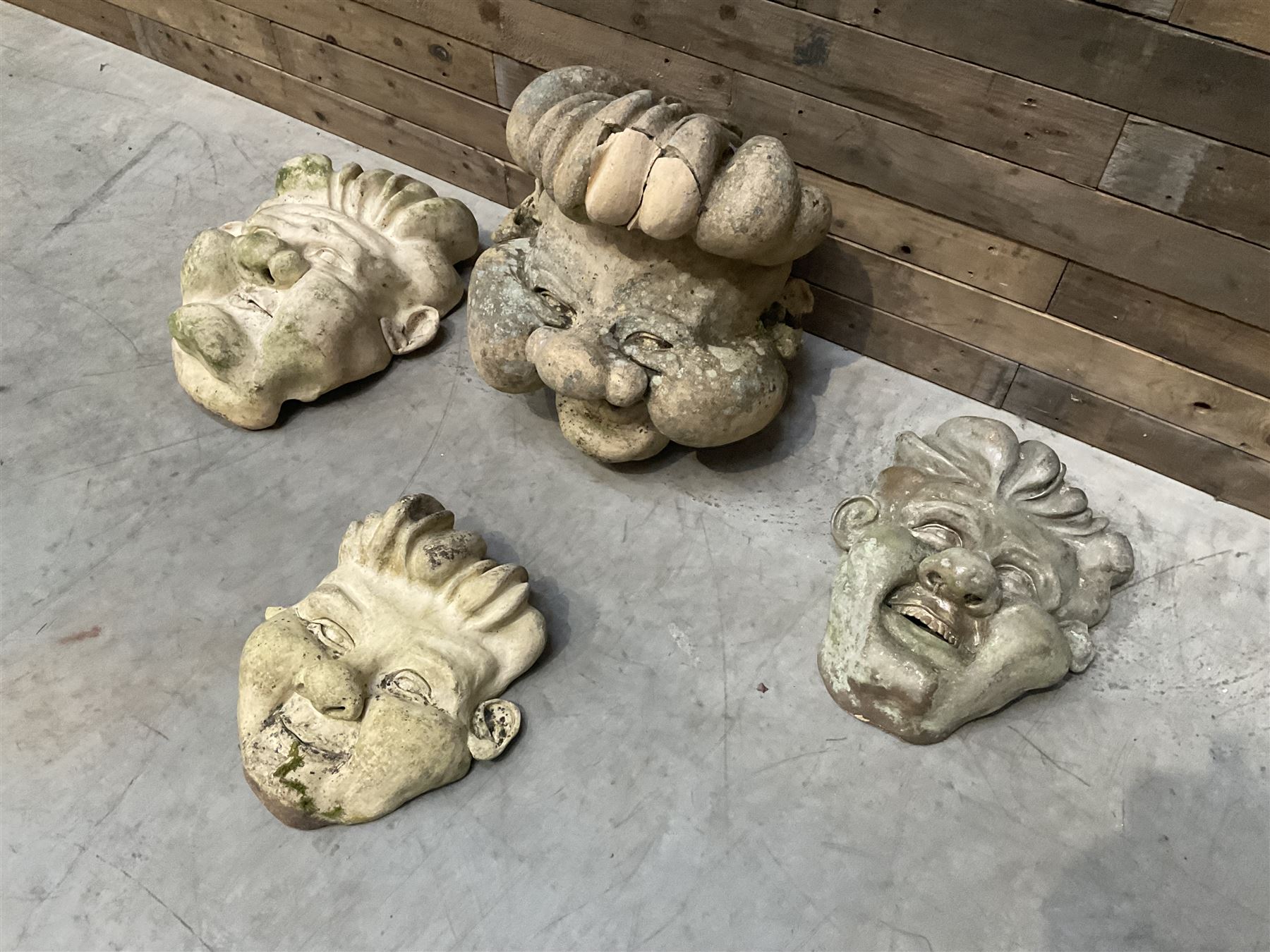 Four grotesque garden wall masks