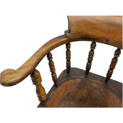 Early 20th century elm and beech smoker's bow type office chair, spindle back with dished seat, on four splayed supports