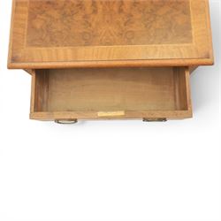 Traditional design pair of walnut lamp tables, figured top with crossbanded edge, above a single frieze drawer with brass oval handles, raised on turned supports