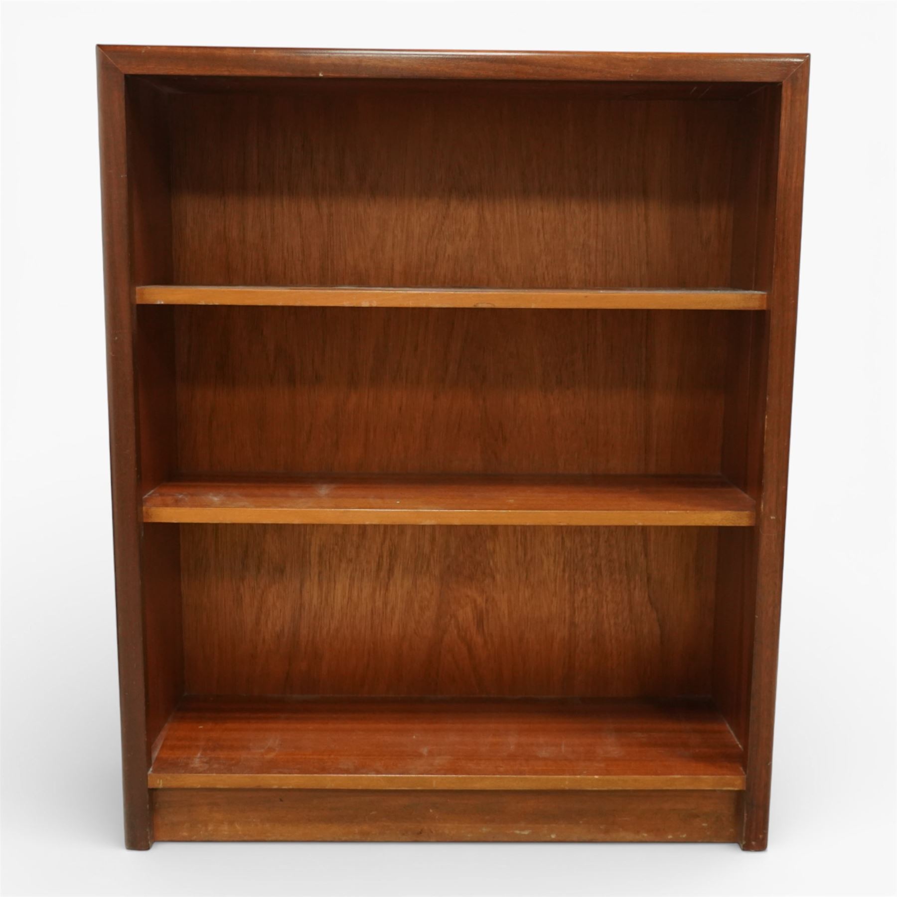 Mid 20th century teak bookcase, of rectangular form with plain top above three open shelves and a shaped plinth base
