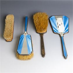 Art Deco four piece dressing table set, comprising hand mirror, two hair brushes and clothes brush, each with blue and white guilloche enamel decoration, hallmarks worn and indistinct