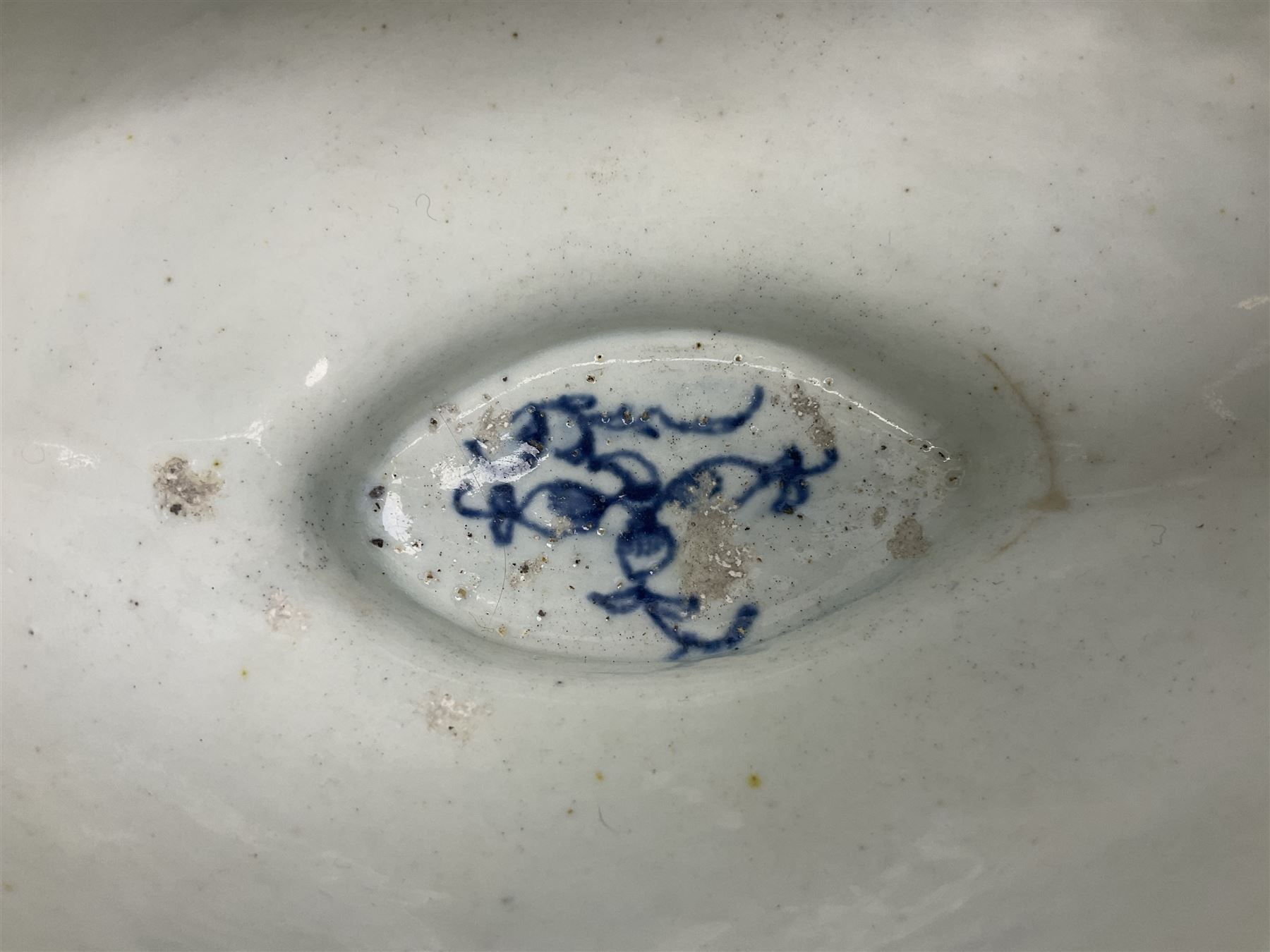 Large 18th century Lowestoft sauce boat, circa 1770, the body decorated with Hughes type floral moulding, and painted in underglaze blue with an Oriental landscape, and foliate sprigs, L23cm