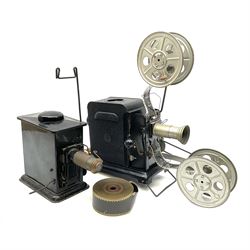 Early 20th century tinplate combined magic lantern and 35mm cinematograph projector, hand-cranked, with electric bayonet lamp, fitted with film reels, L35cm overall, and a similar projector by Gebruder Bing Nuremberg with spirit lamp (glass chimney a/f) L22cm, with two reels of film 
