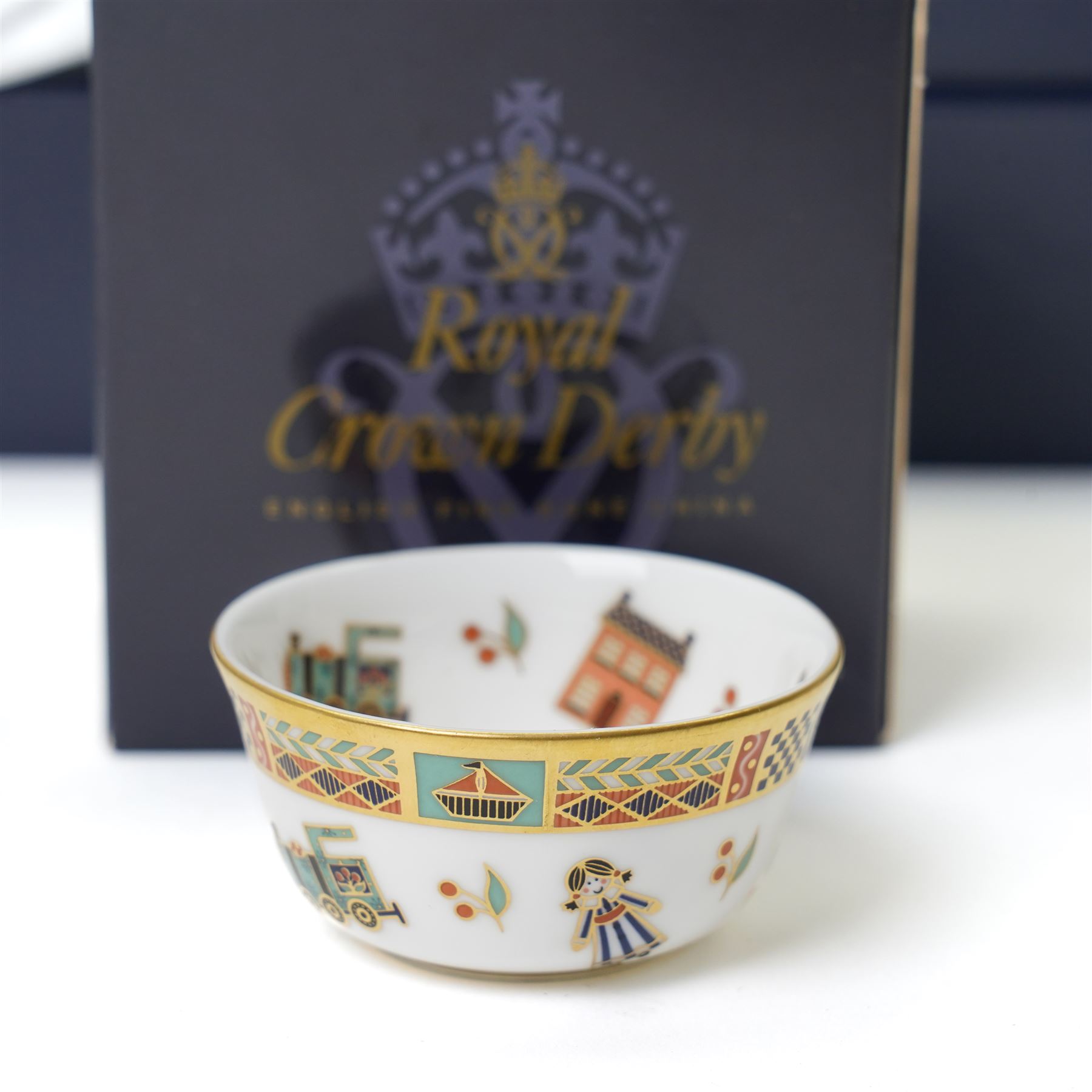 Royal Crown Derby 'Treasures of Childhood' miniature tea service, together with Humpty Dumpty figure, ragdoll, mug, and miniature sugar bowl, all boxed 