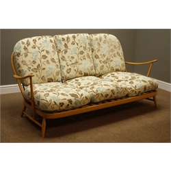  Ercol 'Windsor' light beech finish four piece lounge suit, three seat settee (W174cm), pair 'Windsor' easy armchairs (W72cm), and matching footstool, all with floral upholstered loose cushions  