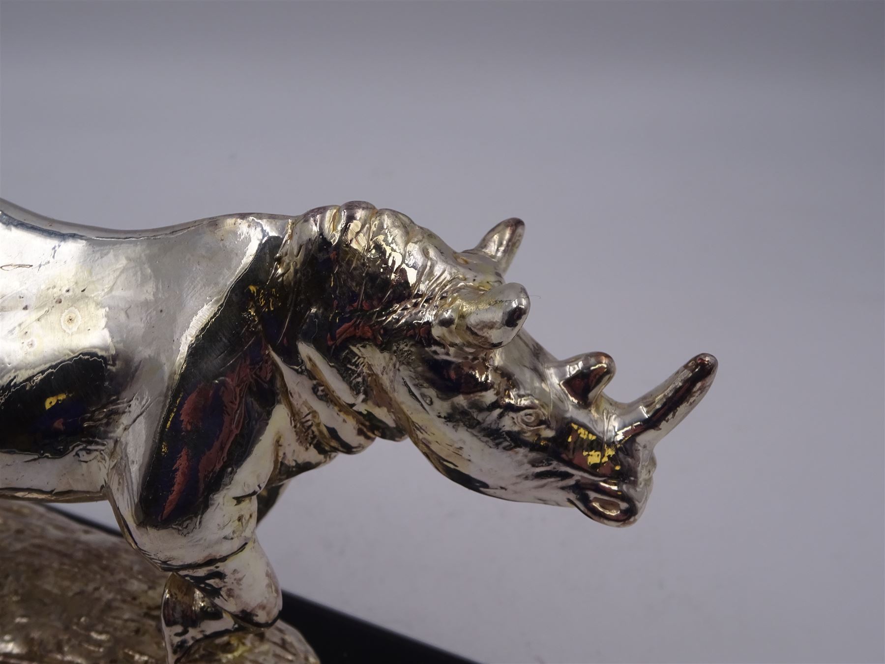 Filled silver model of a rhinoceros by Afrisilver, upon lacquered wooden base, H11.5cm
