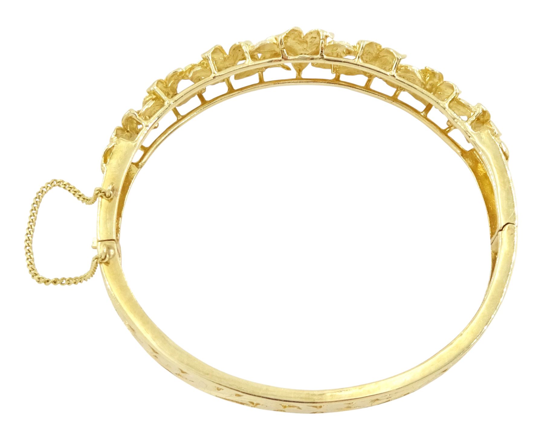 14ct gold diamond flower head hinged bangle, seven graduating flowers, each set with a single round brilliant cut diamond, to a pierced and engraved foliate body, stamped