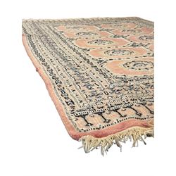 Persian design pale pink ground rug, the field divided into panels and decorated with Gul motifs, wide multi-band border with geometric patterns 