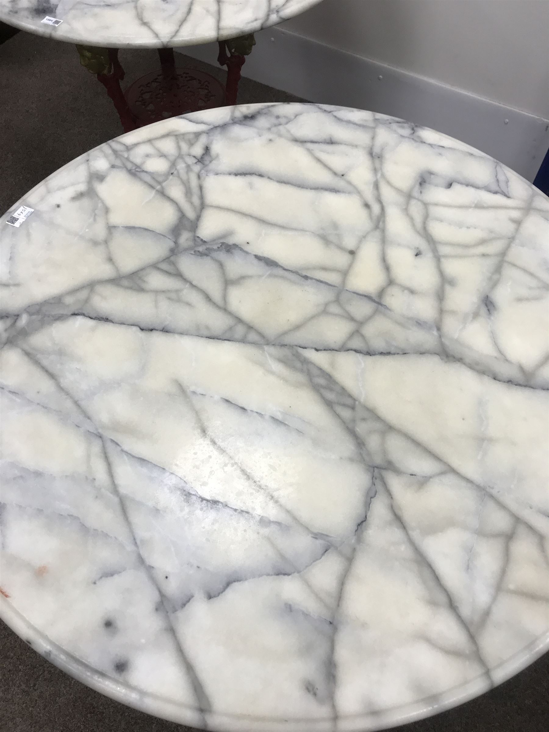 Pair cast iron Britannia pub tables, one red, one black with large marble tops 