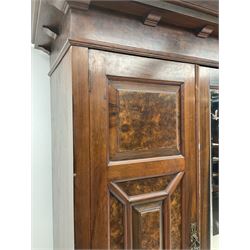 Large late Victorian walnut wardrobe, projecting cornice of central bevelled mirror and two panelled doors, two drawers to base