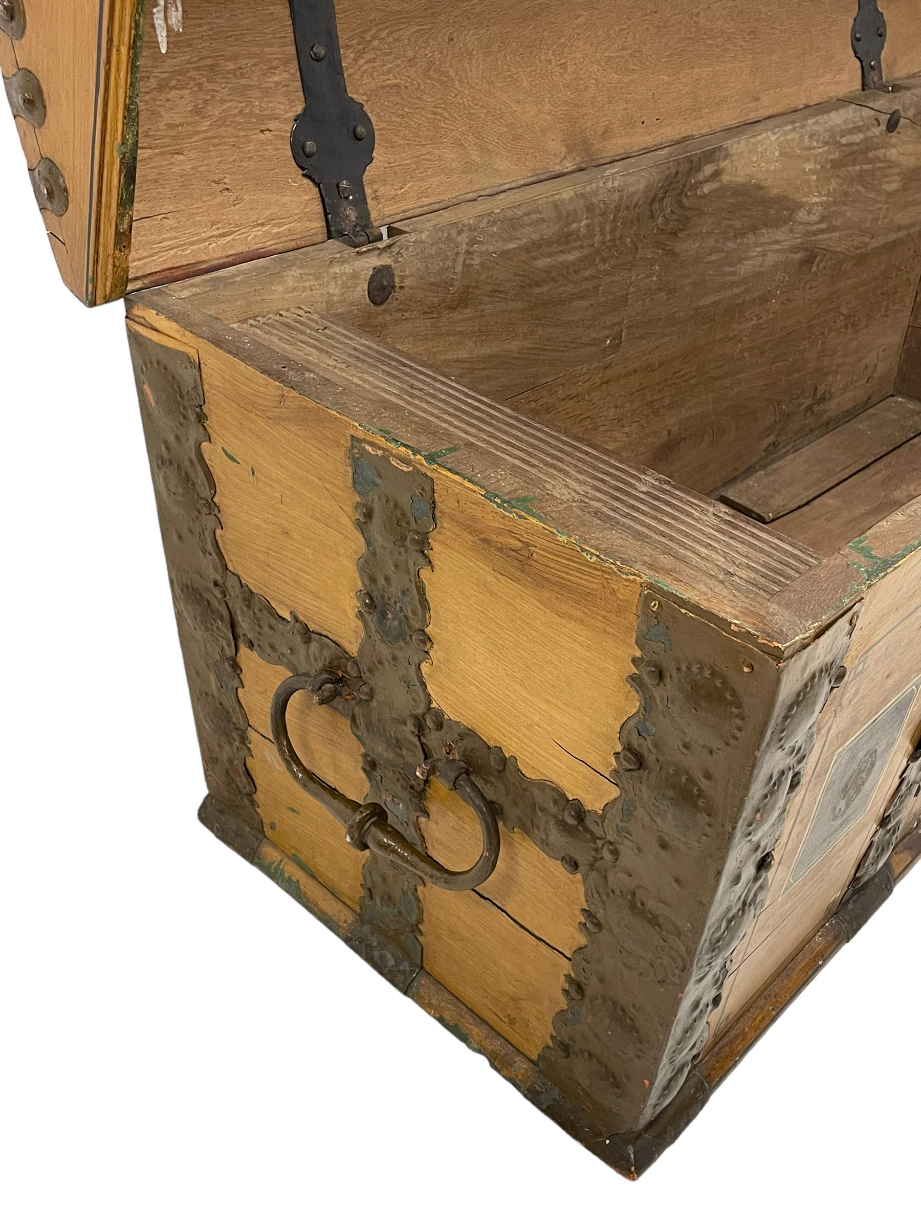 19th century painted oak sea chest, hinged dome top enclosing small compartment, bound by shaped and pressed metal strapwork, scumbled finish to resemble oak and painted with small vignettes depicting portraits and landscapes within panels, fitted with large wrought metal carrying handles, the front inscribed 'H.J.S. 1870' 