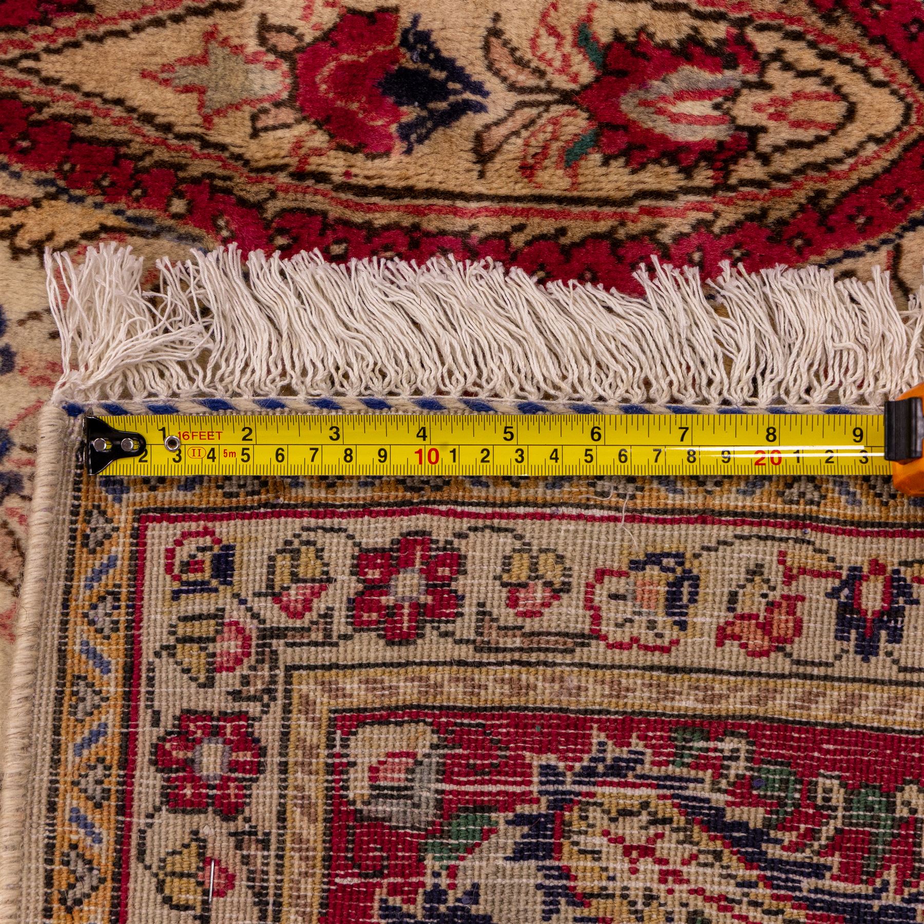 West Central Persian Sarouk hand-knotted carpet, ivory field with central ornate medallion and scrolling vines and palmettes, surrounded by large stylized boteh motifs and flowering foliage, enclosed by a madder-red border of palmettes and floral vine ornament between multiple guard stripes, cotton fringe ends 
